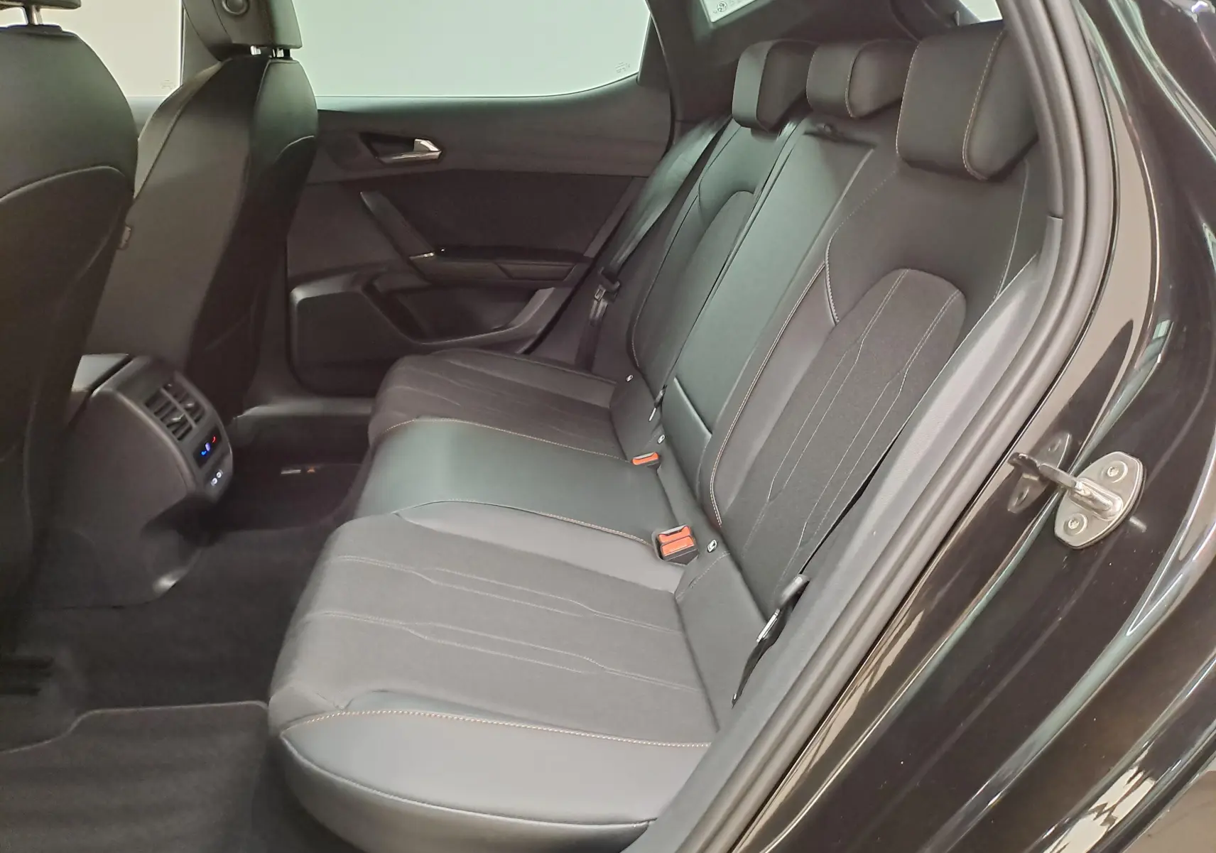 Vue côté droit sur les sièges arrière noirs avec surpiqûres cuivrées du CUPRA Leon Ph.2 1.5 eTSI 2025.