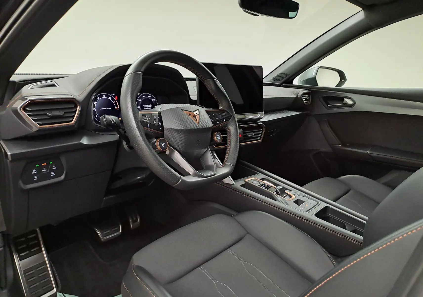 Intérieur avant droit de la CUPRA Leon Ph.2 noir minuit, volant multifonction et écran central tactile moderne.