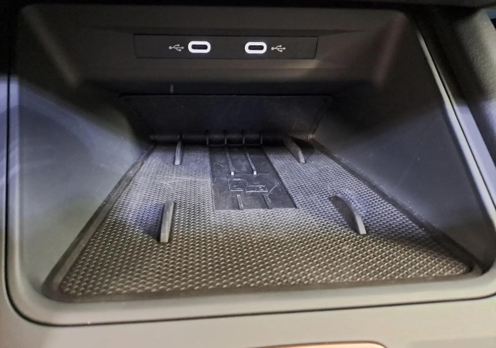 Gros plan sur le compartiment de recharge sans fil avec ports USB-C du CUPRA Leon Ph.2 Noir Minuit 2025.