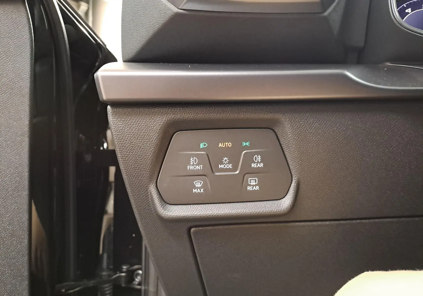 Gros plan sur les commandes d'éclairage à gauche du tableau de bord du CUPRA Leon Ph.2 noir minuit.