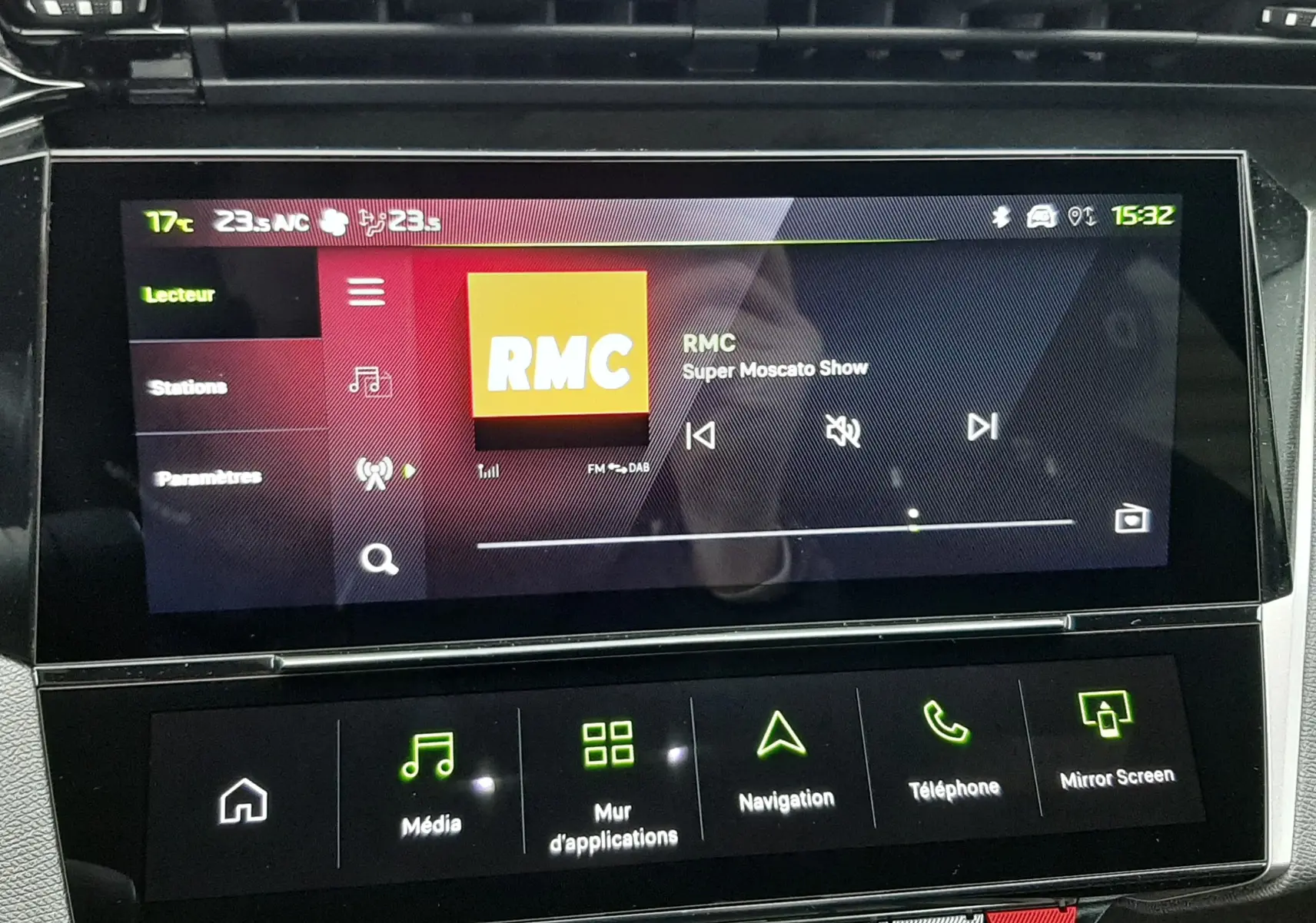 Écran tactile central de la Peugeot 308 1.2 Hybrid 145ch GT, affichant la radio RMC avec interface moderne et commandes tactiles.