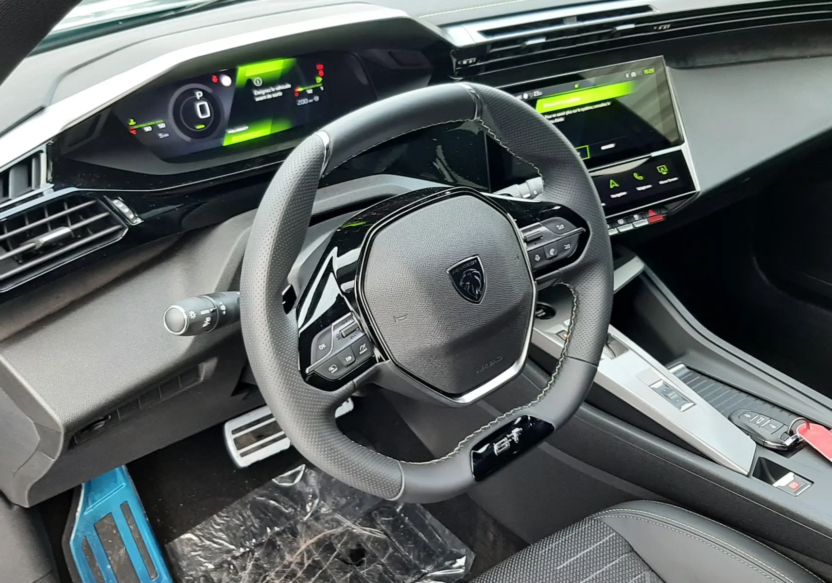 Vue intérieure du poste de conduite de la Peugeot 308 Hybrid 2026, avec volant compact GT et tableau de bord numérique.