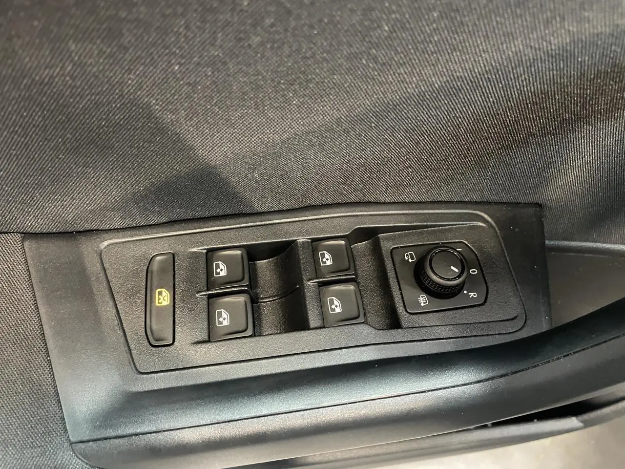 Panneau de commandes des vitres et rétroviseurs côté conducteur du Volkswagen T-Roc gris Indium.