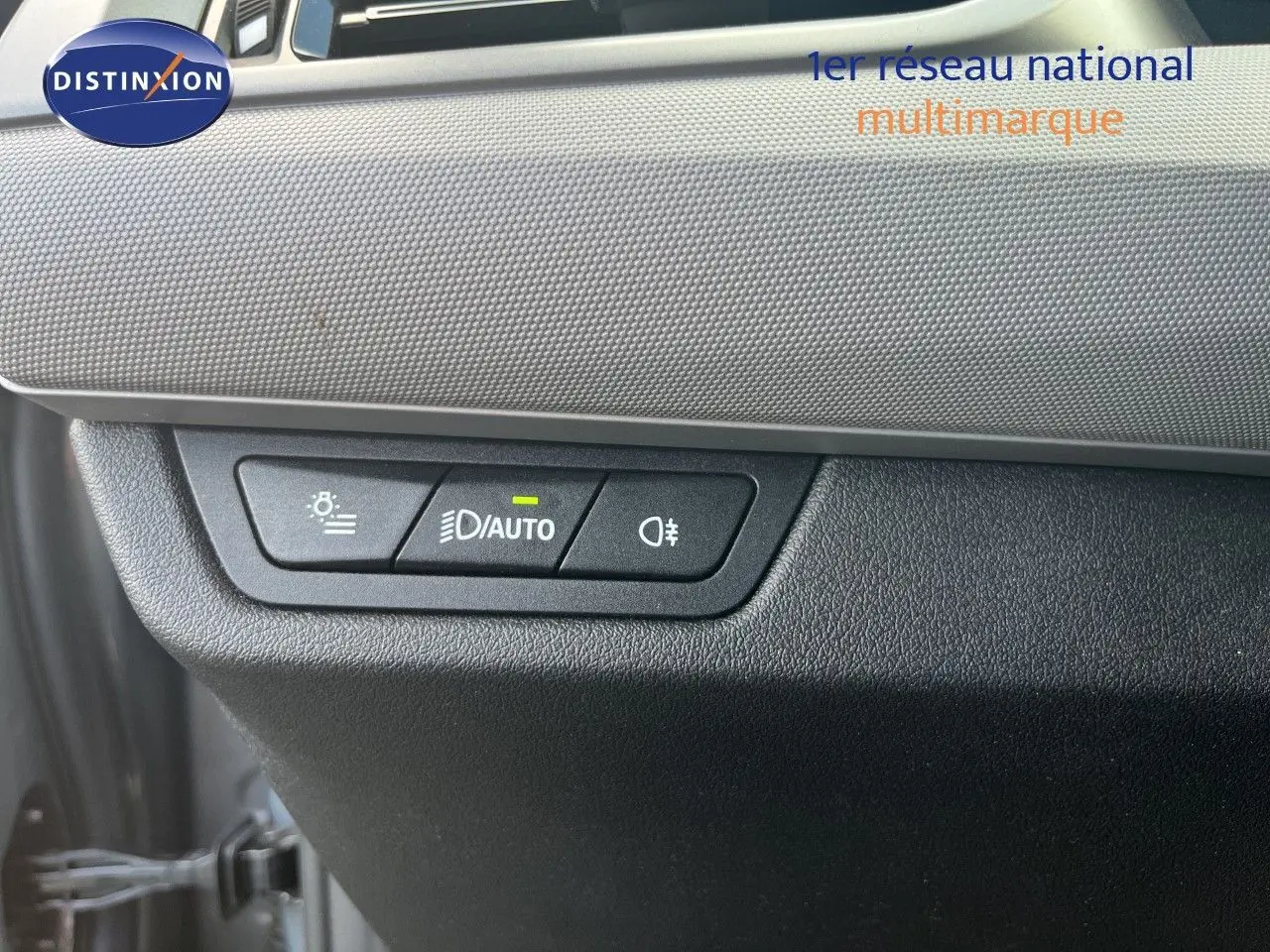 Gros plan sur les commandes d’éclairage avec bouton auto allumé, tableau de bord gris et noir d’une BMW Série 2 Active Tourer 2022.