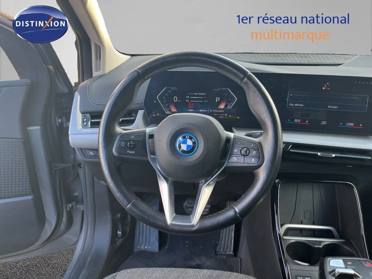 Vue intérieure centrée sur le volant cuir noir et le tableau de bord digital d'une BMW Série 2 Active Tourer 225e XDrive 2022.