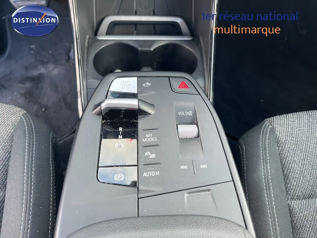 Vue plongeante sur la console centrale de la BMW Série 2 Active Tourer grise, montrant la commande de boîte automatique et les boutons de contrôle.