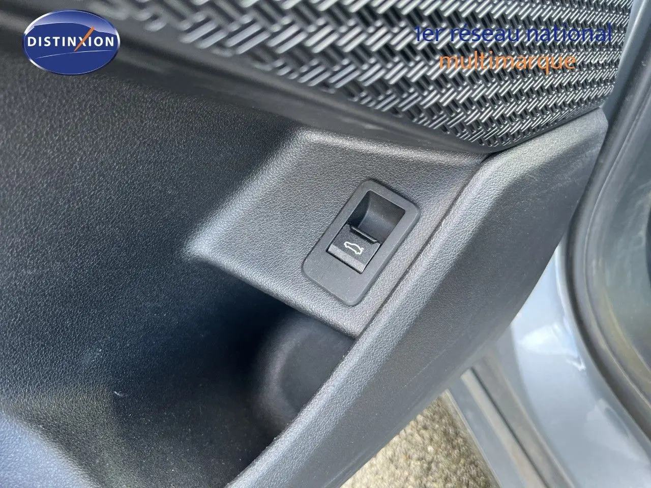 Détail du bouton d'ouverture du coffre sur la porte côté gauche d'une BMW Série 2 Active Tourer gris métallisé.