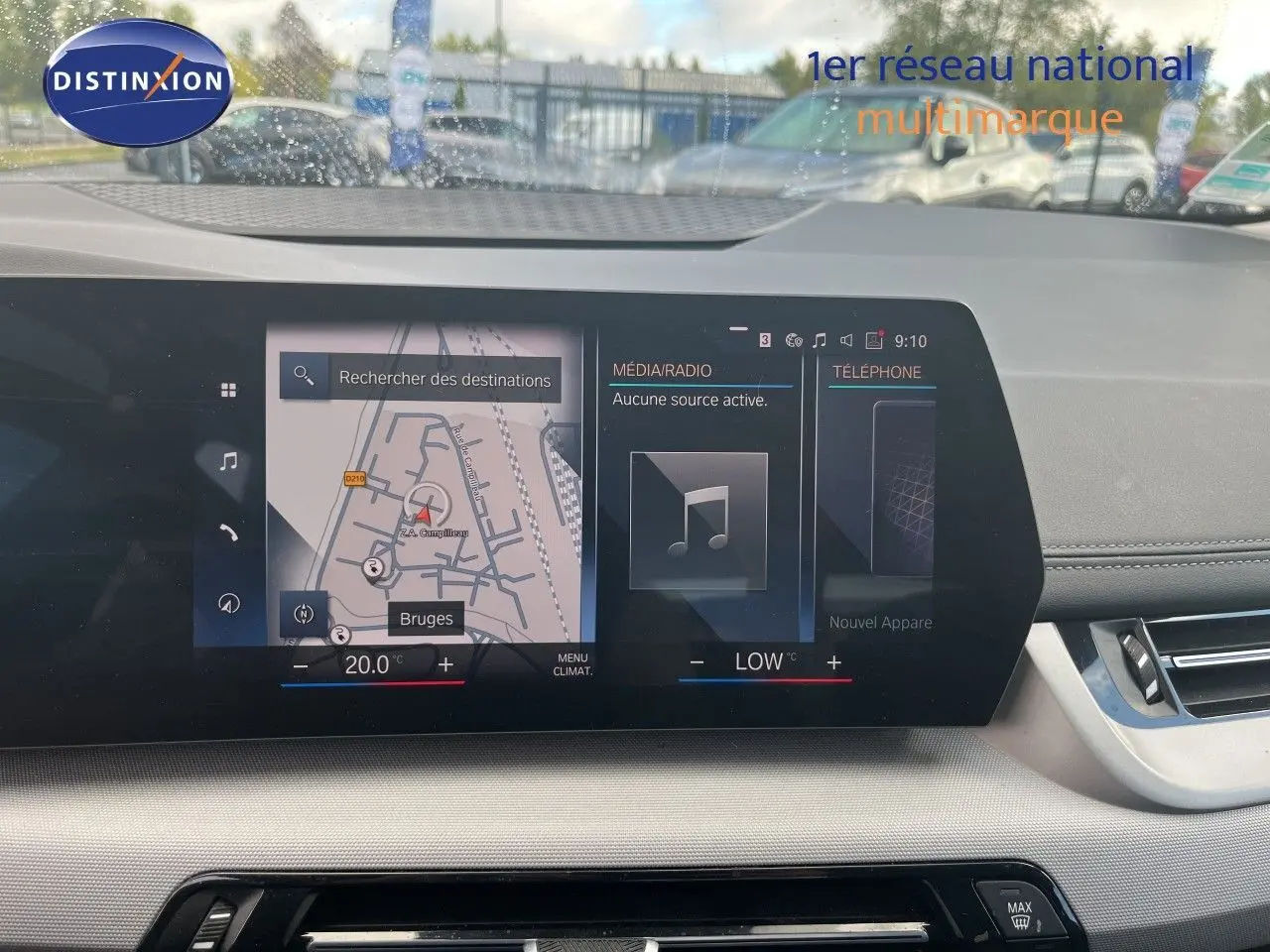 Vue intérieure du tableau de bord de la BMW Série 2 Active Tourer 225e XDrive avec écran tactile affichant la navigation et la climatisation.
