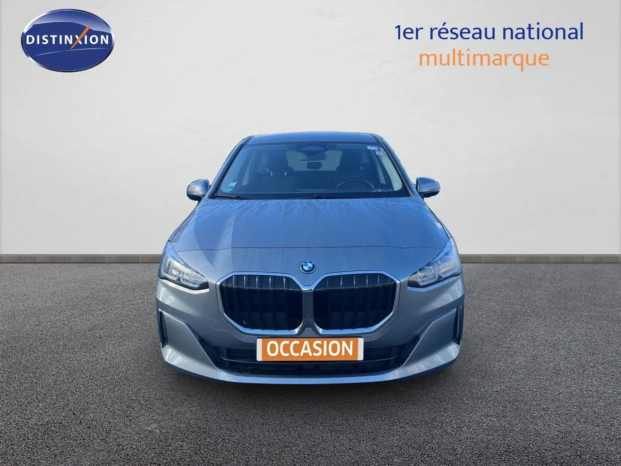 Vue frontale d'une BMW Série 2 Active Tourer 225e xDrive grise métallisée avec calandre noire et plaque "OCCASION".