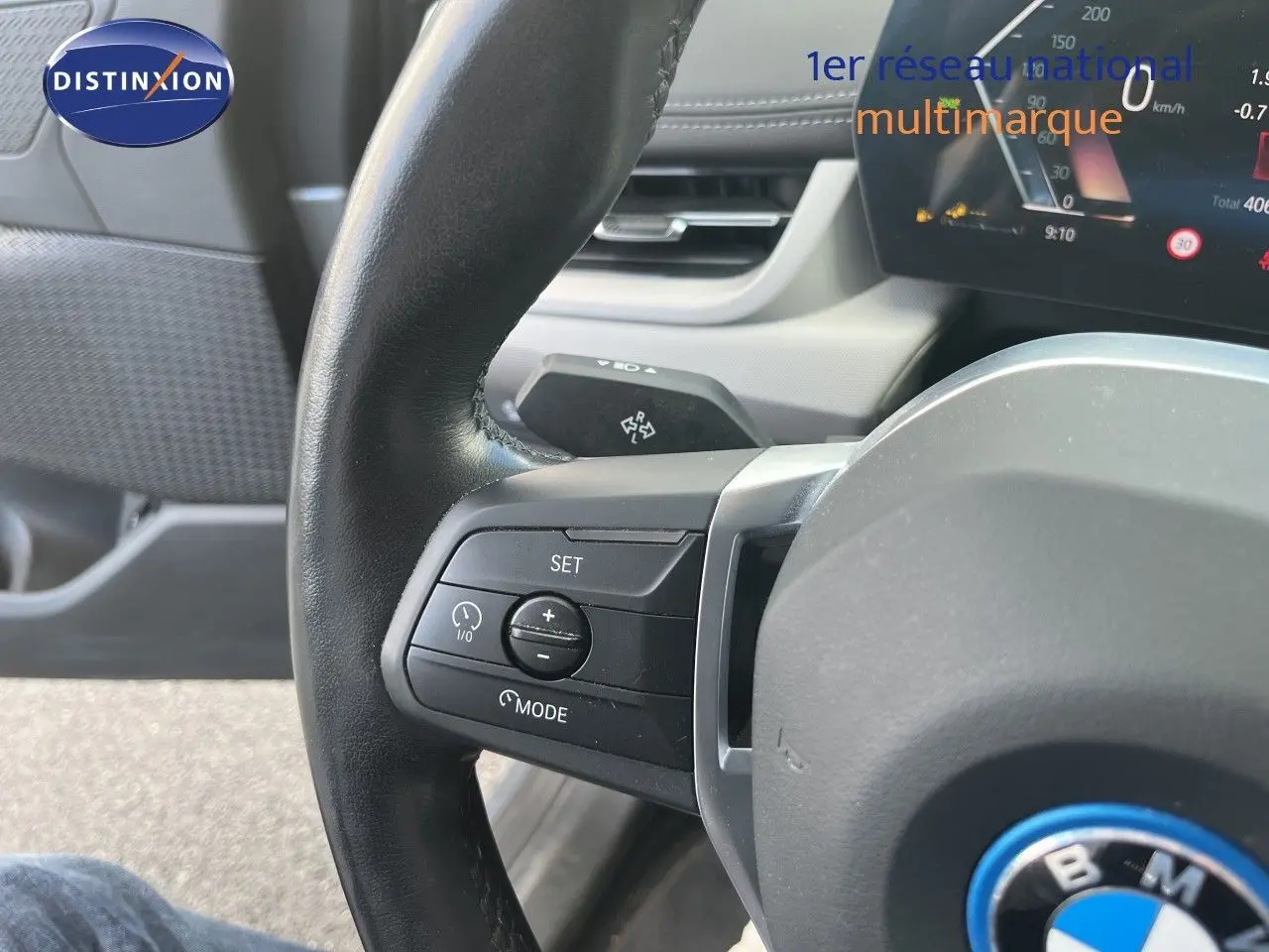 Gros plan sur le volant cuir noir de la BMW Série 2 Active Tourer 225e XDrive, avec commandes intégrées et tableau de bord numérique.
