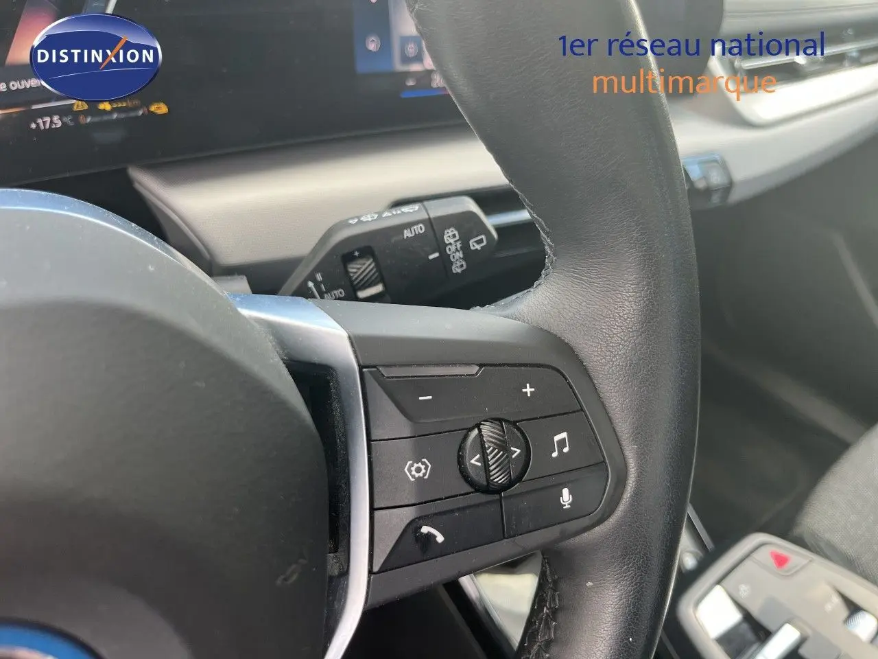 Gros plan sur la partie droite du volant noir d’une BMW Série 2 Active Tourer 225e xDrive grise, avec commandes multimédia visibles.