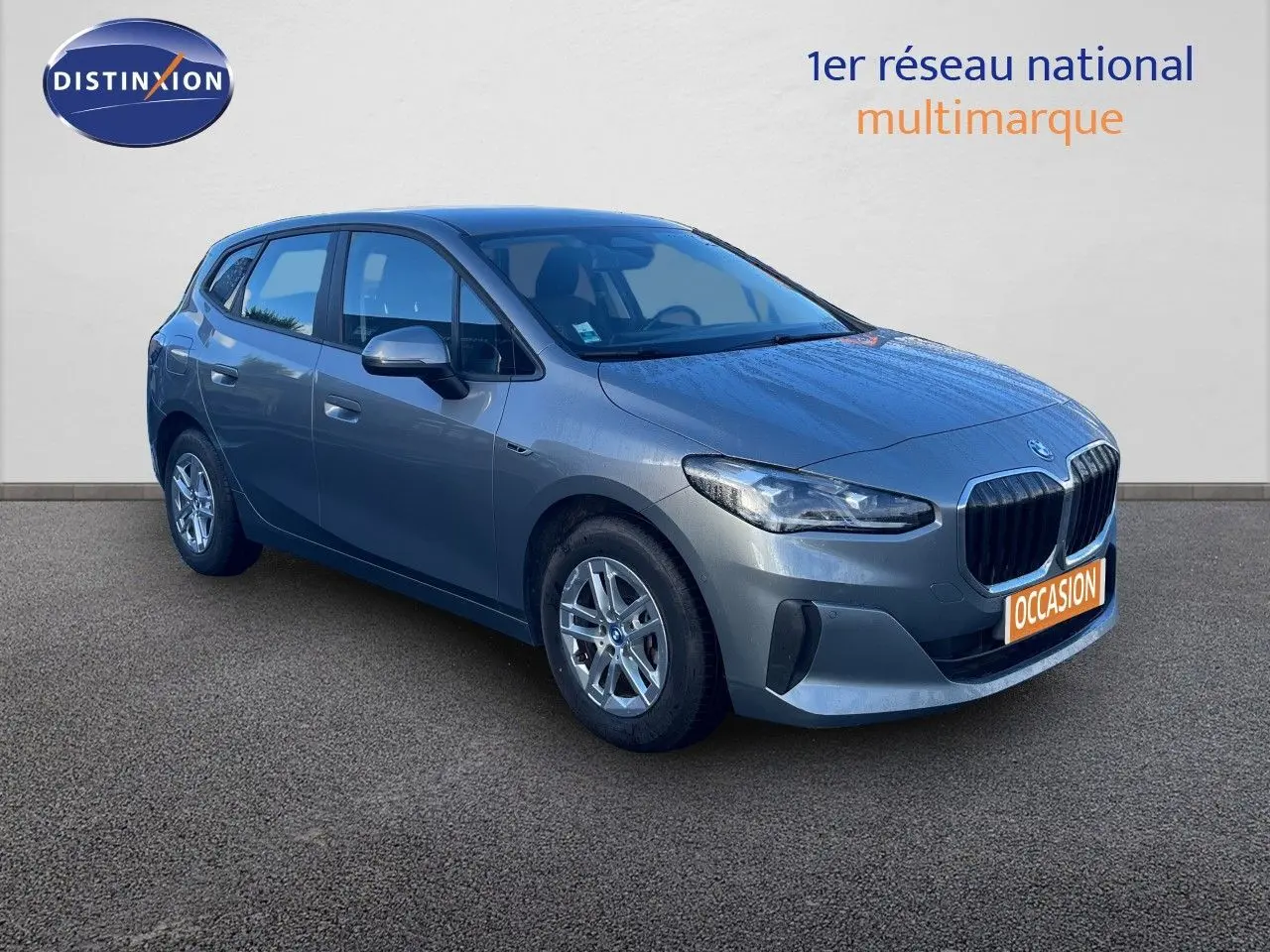 Vue 3/4 avant droite d'une BMW Série 2 Active Tourer hybride gris métallisé avec calandre imposante et jantes argentées.
