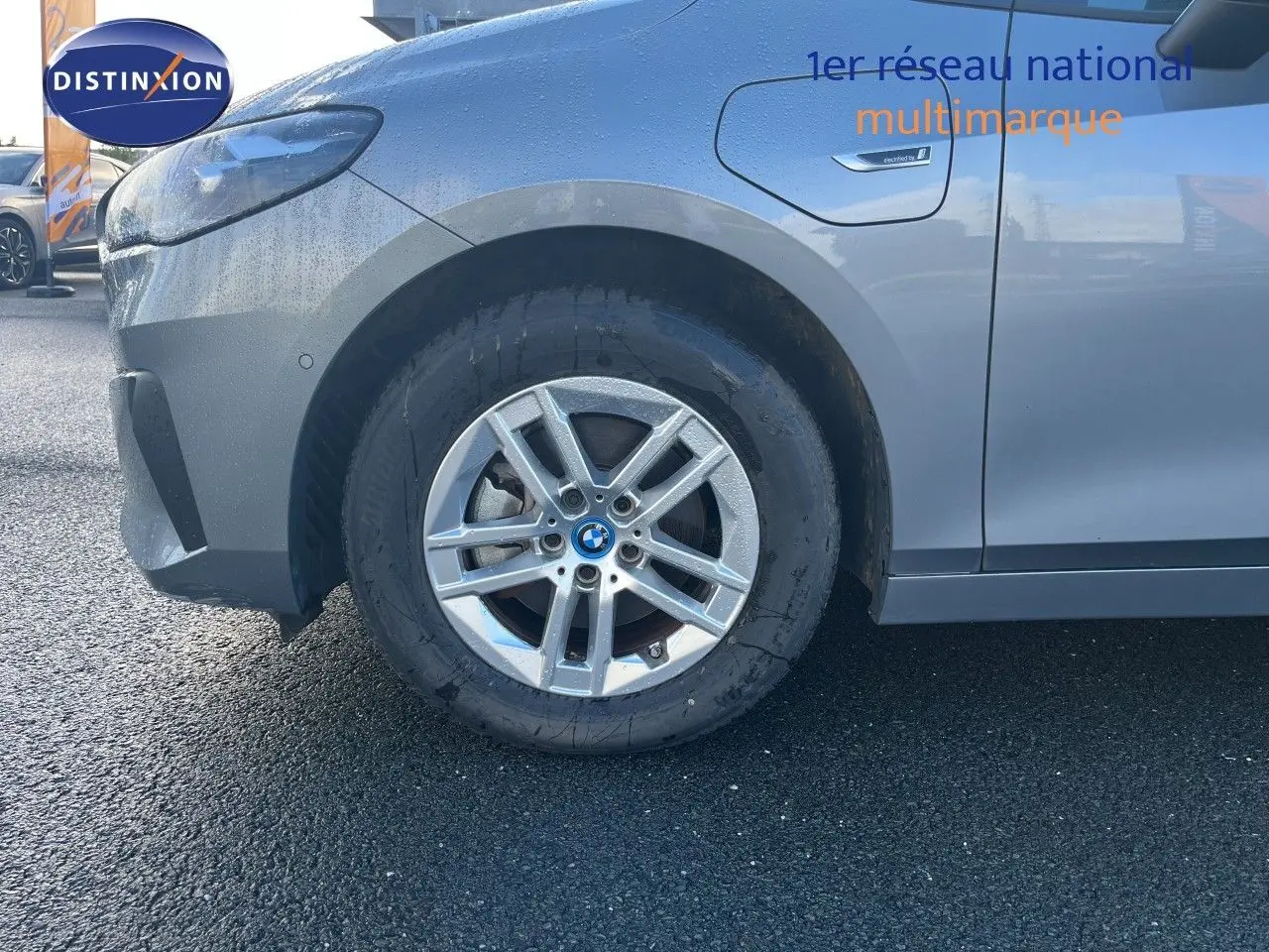 Gros plan sur la roue avant gauche d'une BMW Série 2 Active Tourer gris métallisé avec badge "electrified" sur l'aile.