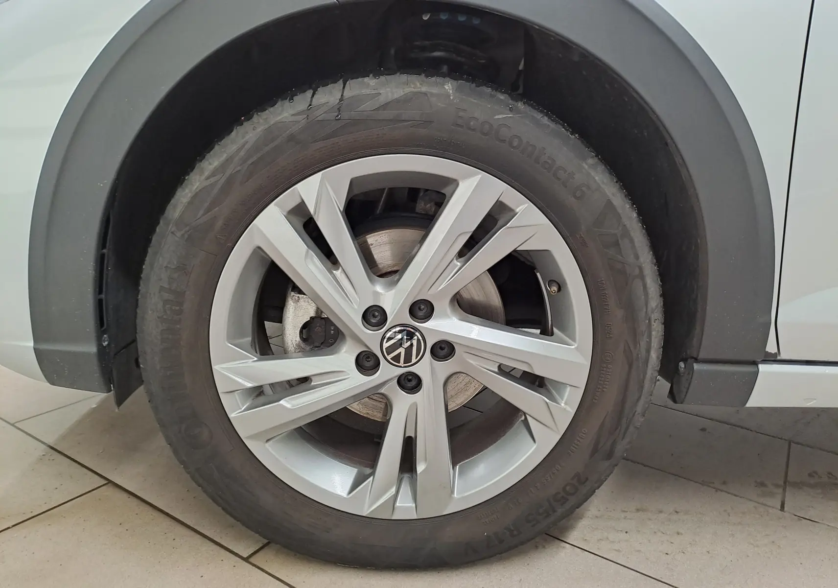 Gros plan sur la roue avant gauche d'un Volkswagen Taigo 2024 en peinture métallisée Reflet d'argent avec jante alliage R-Line.