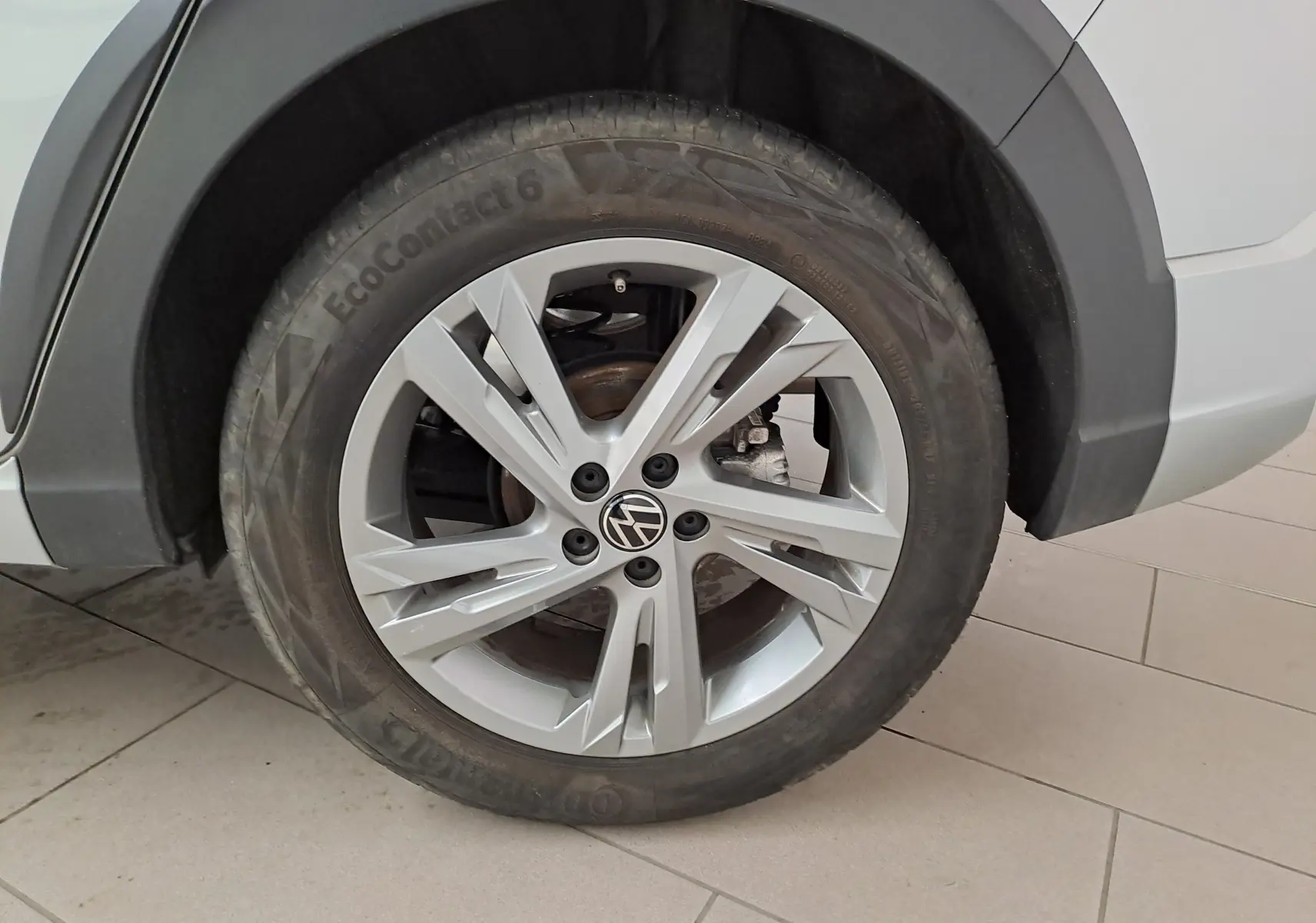 Gros plan sur la roue avant gauche du Volkswagen Taigo 2024 en peinture métallisée Reflet d'argent avec jante alliage R-Line.