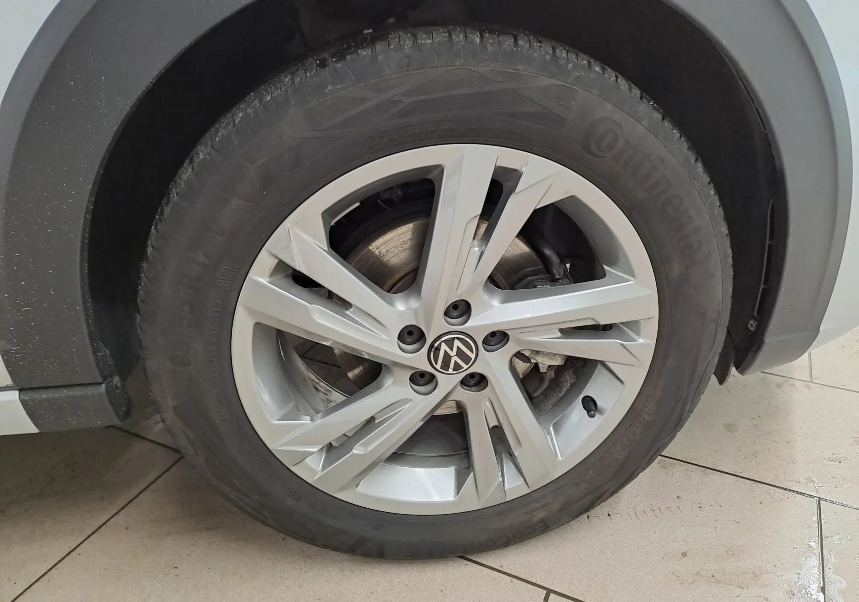 Gros plan sur la roue avant droite du Volkswagen Taigo 2024 en peinture métallisée Reflet d'argent avec jante alliage R-Line.