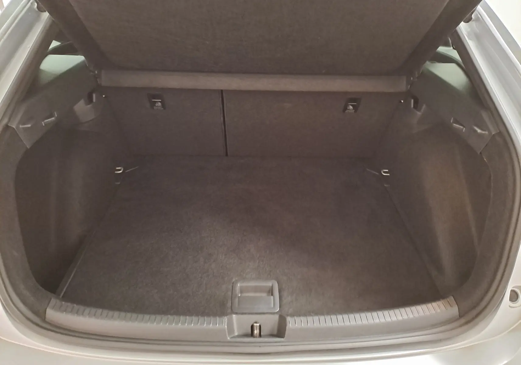 Coffre ouvert du Volkswagen Taigo 1.0 TSI 110 DSG7 R-Line en Reflet d'argent, montrant l'espace de chargement vide.