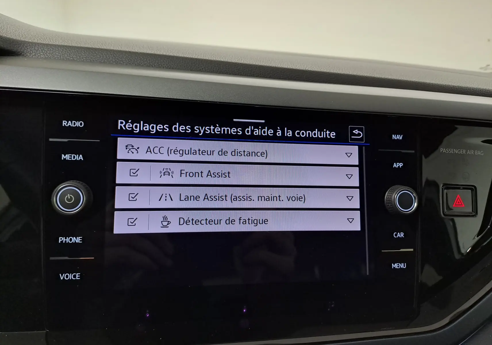 Écran central du Volkswagen Taigo 2024 affichant les réglages des aides à la conduite avec interface moderne noire.