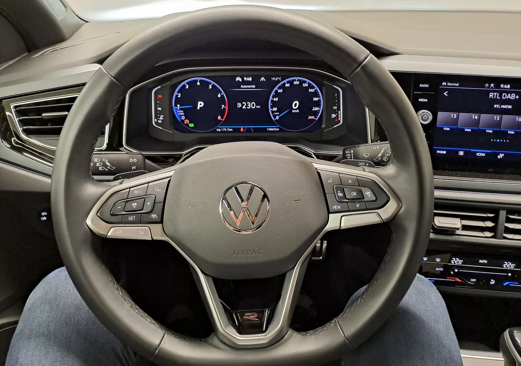 Vue rapprochée du volant multifonction noir du Volkswagen Taigo 2024 avec tableau de bord numérique et écran central.