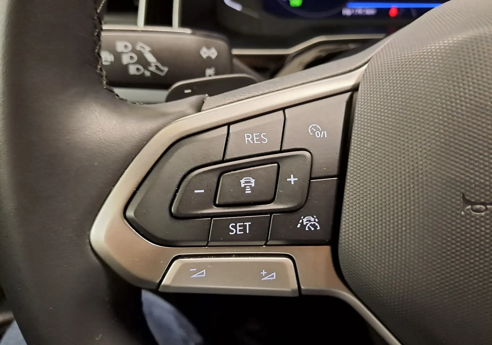 Gros plan sur les commandes de régulateur de vitesse au volant du Volkswagen Taigo 1.0 TSI R-Line de 2024.