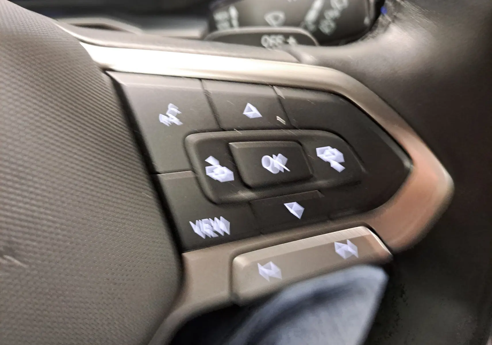 Gros plan sur les commandes au volant du Volkswagen Taigo 2024, version R-Line, avec boutons multifonctions et finition argentée.