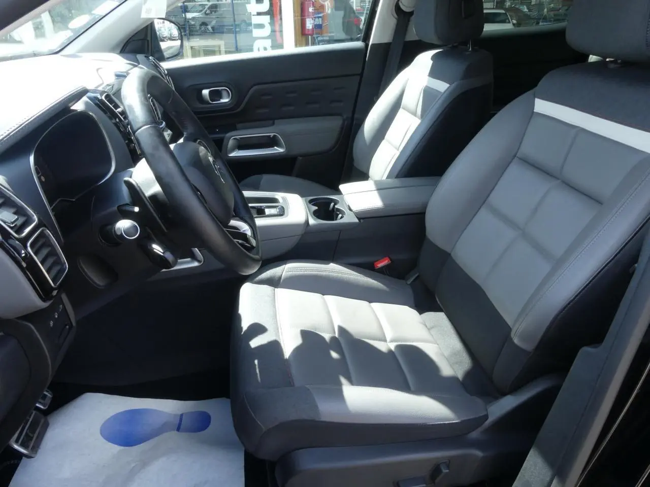 Intérieur avant du Citroën C5 Aircross 2020, sièges cuir gris et volant en cuir noir, vue côté conducteur.