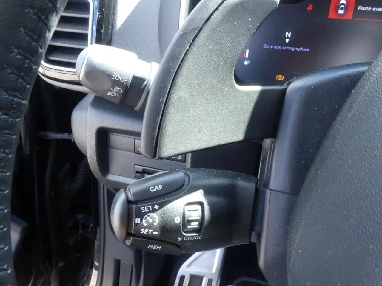 Commande de régulateur de vitesse noire sur le volant cuir du Citroën C5 Aircross 2020, vue intérieure côté gauche.