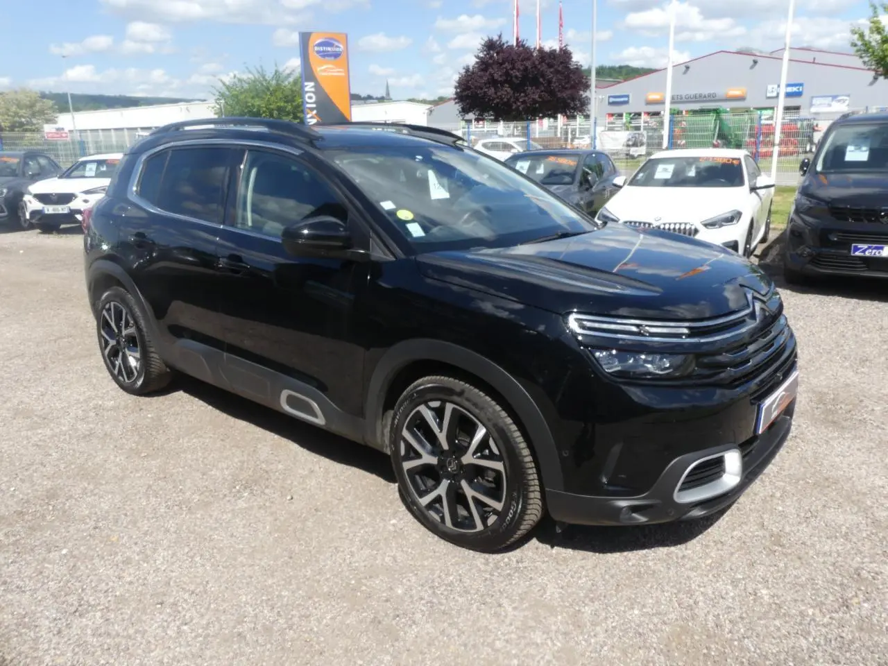 Vue 3/4 avant d'un SUV Citroën C5 Aircross noir nacré avec jantes alliage et protections latérales grises.
