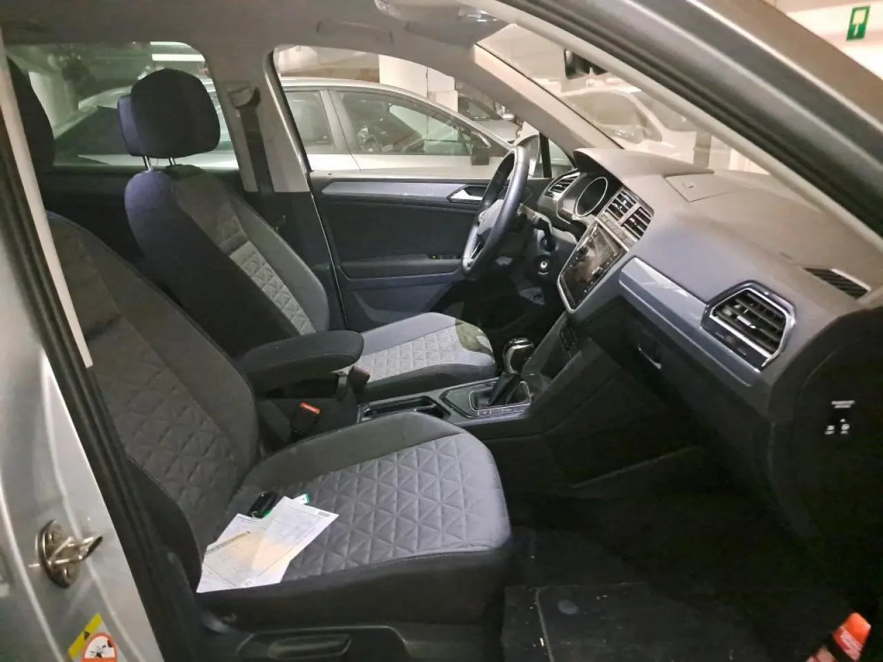 Intérieur avant du Volkswagen Tiguan 2.0 TDI 2022 avec sièges gris et tableau de bord moderne visible côté conducteur.