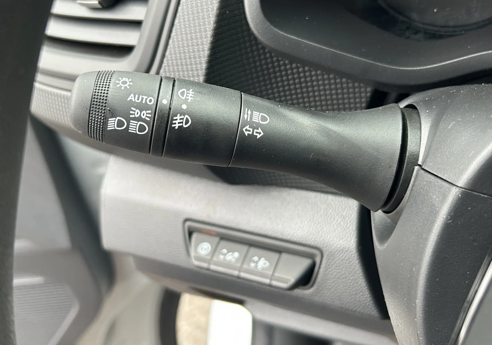 Gros plan sur la manette de commande des phares et clignotants du Renault Trafic Combi L2 Grand Evolution blanc.