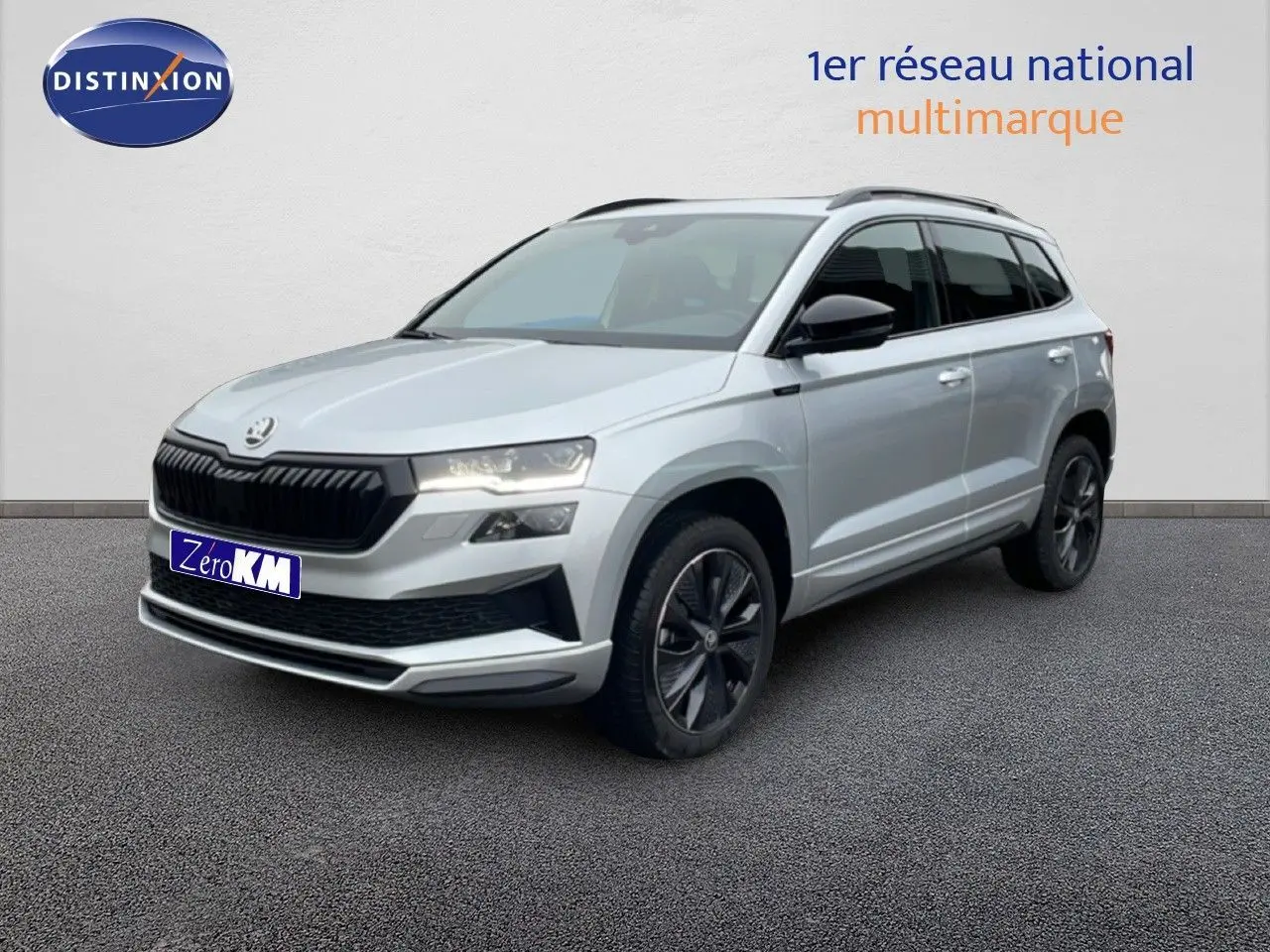 Vue 3/4 avant d'un Skoda Karoq gris argent métallisé avec jantes noires et calandre noire sportive.