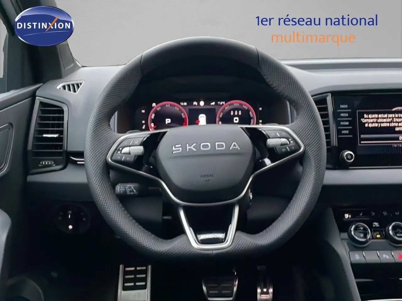 Vue intérieure centrée sur le volant sport SKODA KAROQ 2025, tableau de bord numérique et écran multimédia visibles.