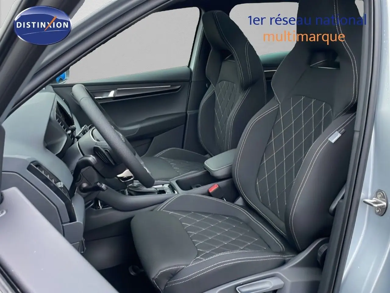 Vue intérieure côté gauche du Skoda Karoq 1.5 TSI 150ch Sportline 2025, sièges sport noirs avec surpiqûres blanches.