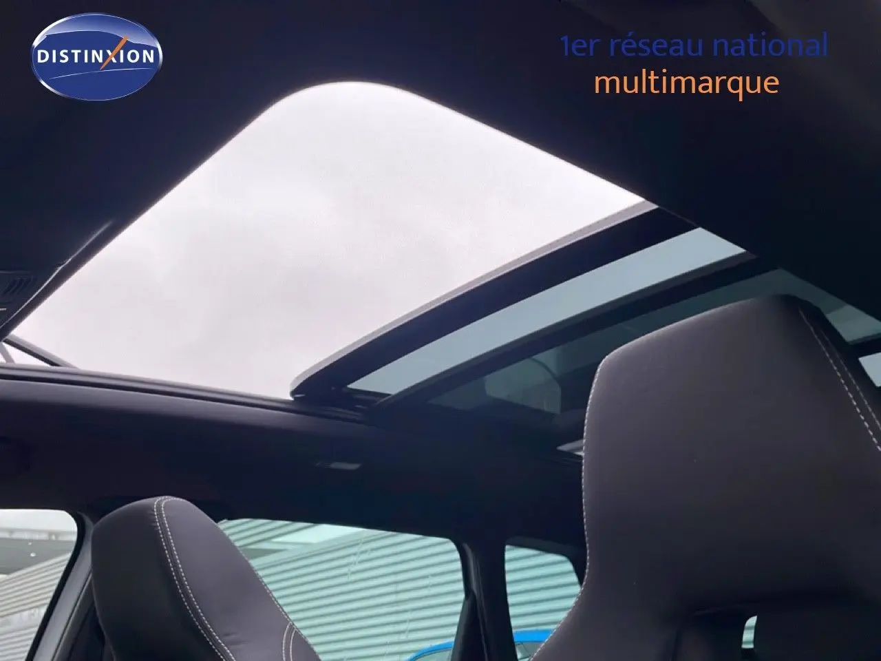 Vue intérieure du toit ouvrant panoramique et sièges avant en tissu noir du Skoda Karoq gris argent 2025 Sportline.