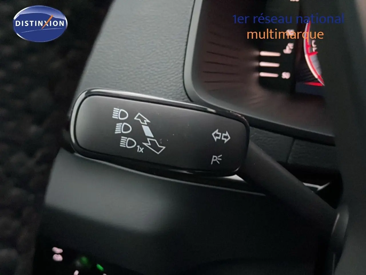 Gros plan sur la manette de clignotant et feux du Skoda Karoq 1.5 TSI gris argent, intérieur noir visible en arrière-plan.