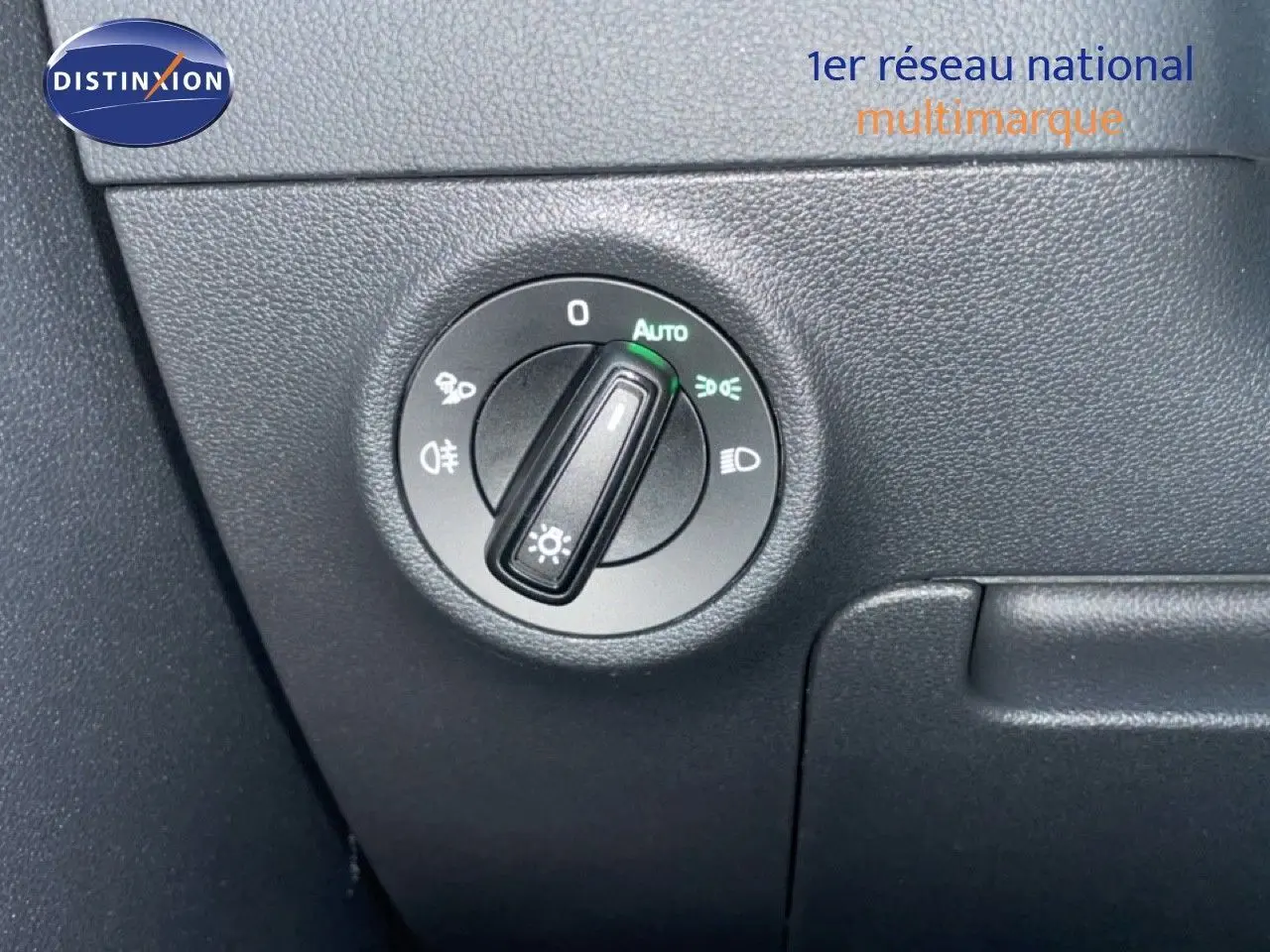 Gros plan sur le bouton de commande des phares du Skoda Karoq gris argent 2025, intérieur noir.