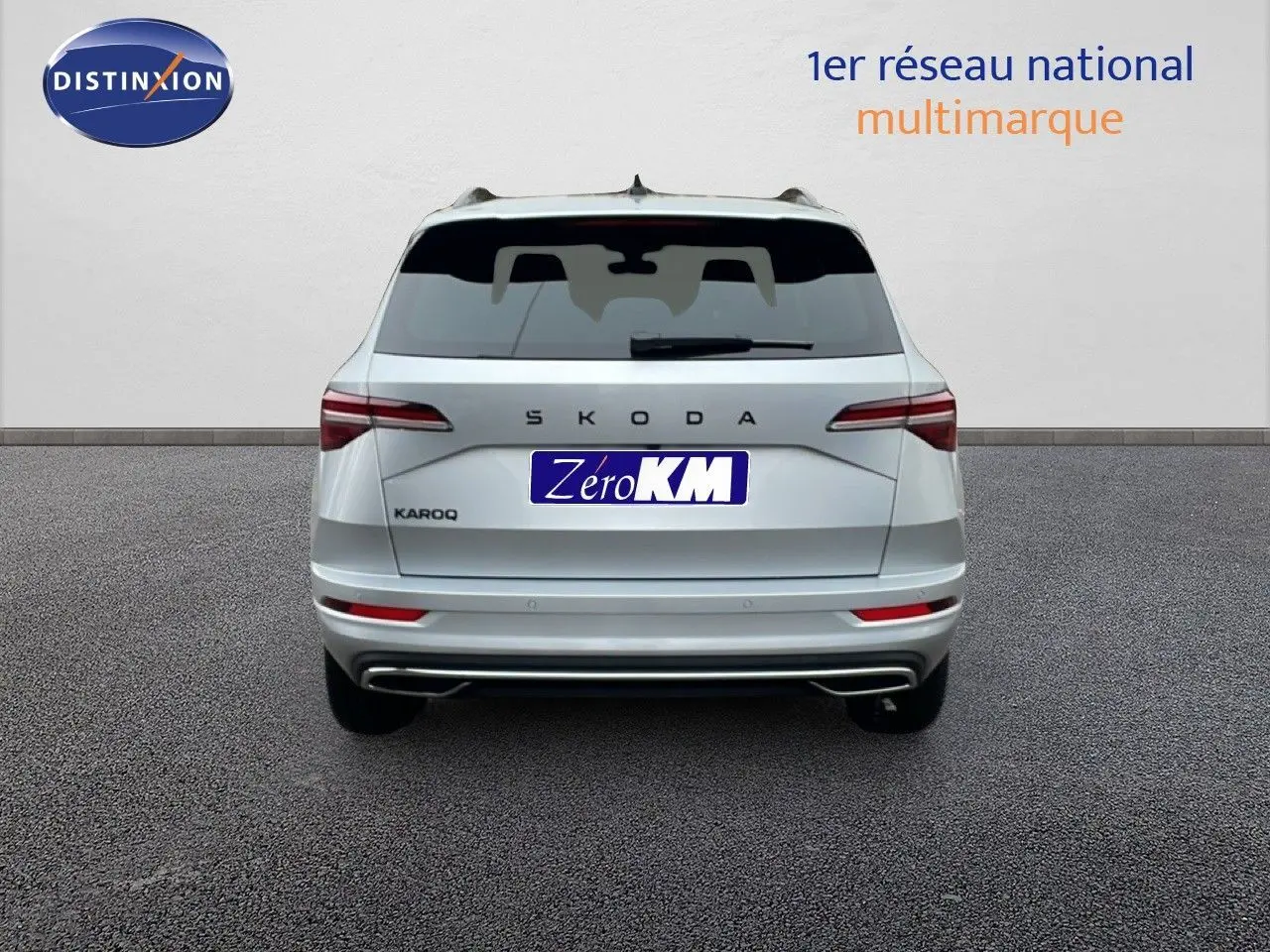 Vue arrière d'un Skoda Karoq gris argent métallisé 2025 avec logo SKODA et feux arrière allongés.