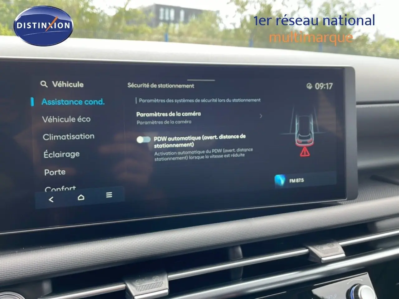 Vue rapprochée de l'écran tactile intérieur du Hyundai Tucson blanc Atlas montrant les paramètres d'assistance à la conduite.