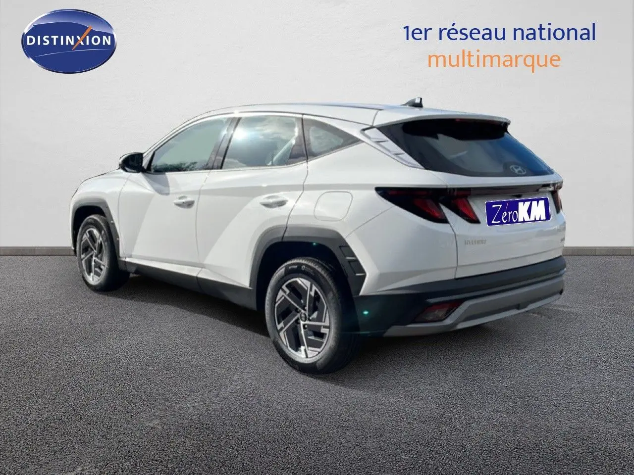 Vue 3/4 arrière droite d'un Hyundai Tucson blanc Atlas 2026 avec jantes bi-ton et feux arrière LED distinctifs.