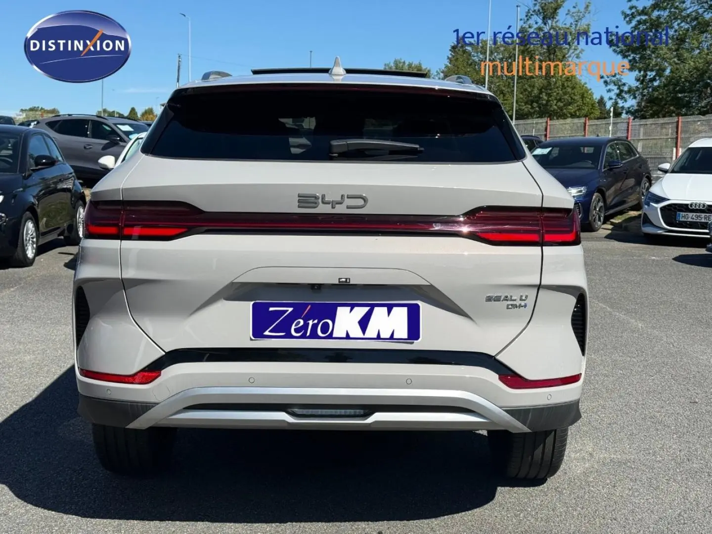 Vue arrière d'un BYD SEAL U hybride rechargeable en blanc métallisé avec feux LED et logo distinctif sur parking.
