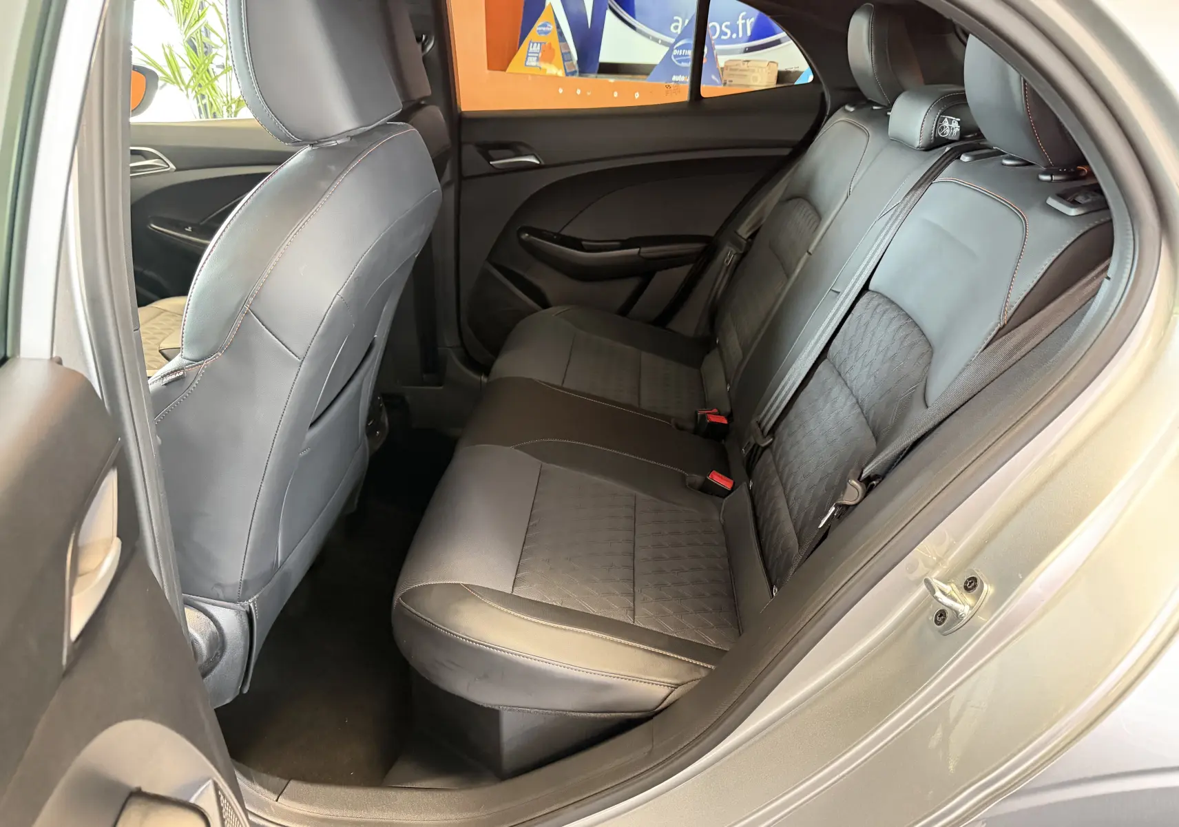 Vue côté droit de l’habitacle arrière du MG3 1.5 L Hybrid+ 2025 en cosmic silver avec sièges en similicuir noir.