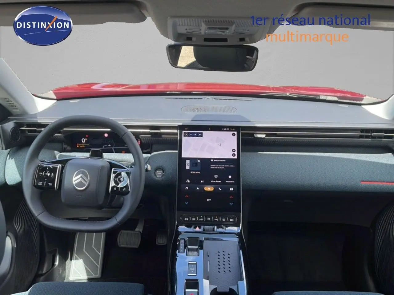 Vue intérieure frontale du tableau de bord et volant du Citroën C5 Aircross Hybrid rouge rubis, avec écran tactile central vertical.