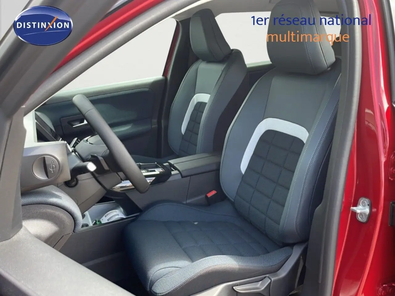 Vue intérieure côté conducteur du Citroën C5 Aircross Hybrid 2026 rouge rubis, sièges tissu noir avec surpiqûres grises.