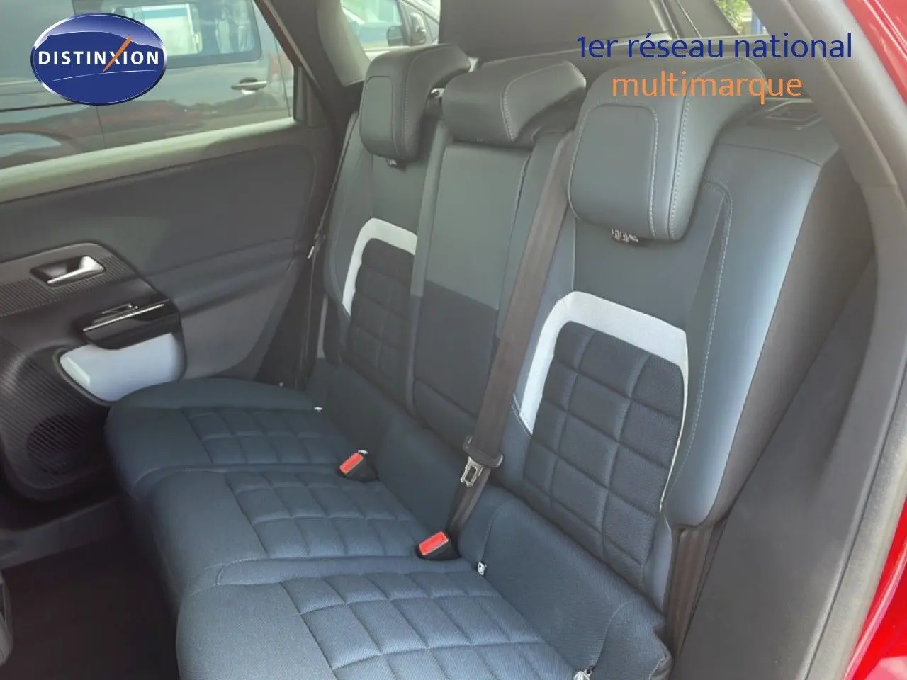 Vue intérieure côté arrière droit du Citroën C5 Aircross rouge rubis, montrant les sièges arrière en tissu noir à motifs carrés.