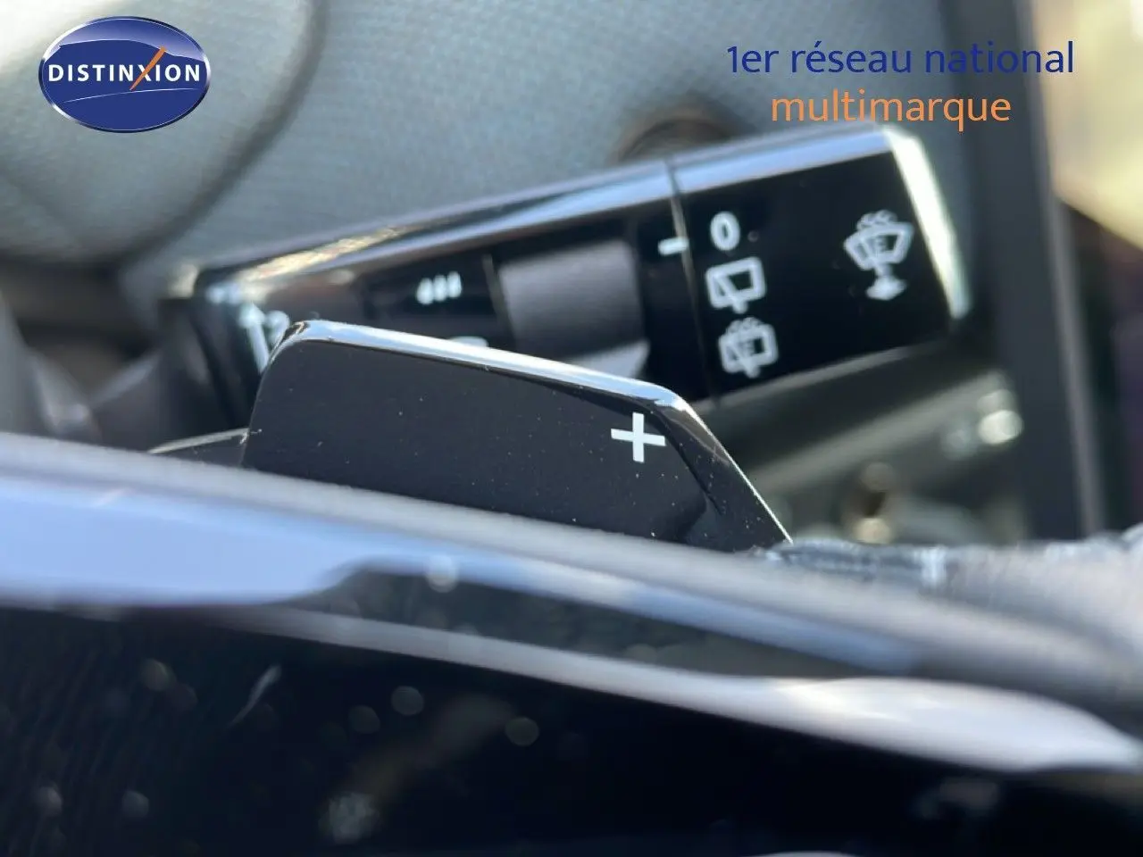 Gros plan sur la palette de changement de vitesse "+" côté droit du volant dans un intérieur de Citroën C5 Aircross rouge rubis.