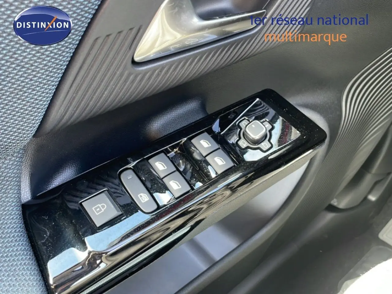 Gros plan sur les commandes de lève-vitres et rétroviseurs côté conducteur du Citroën C5 Aircross Hybrid rouge rubis métal.