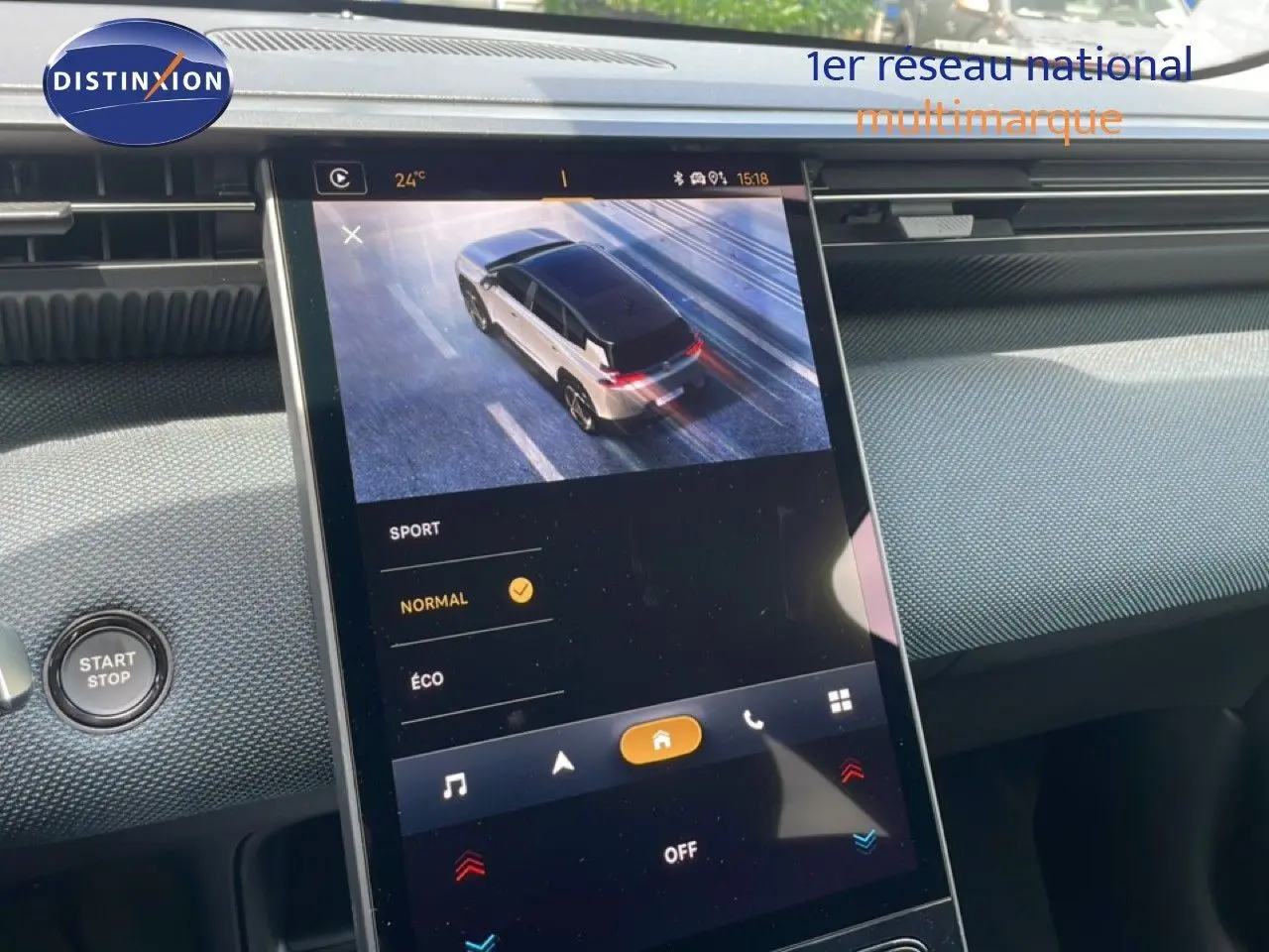Écran central tactile du tableau de bord du Citroën C5 Aircross Hybrid rouge rubis, affichant la vue 3/4 arrière du véhicule en conduite.