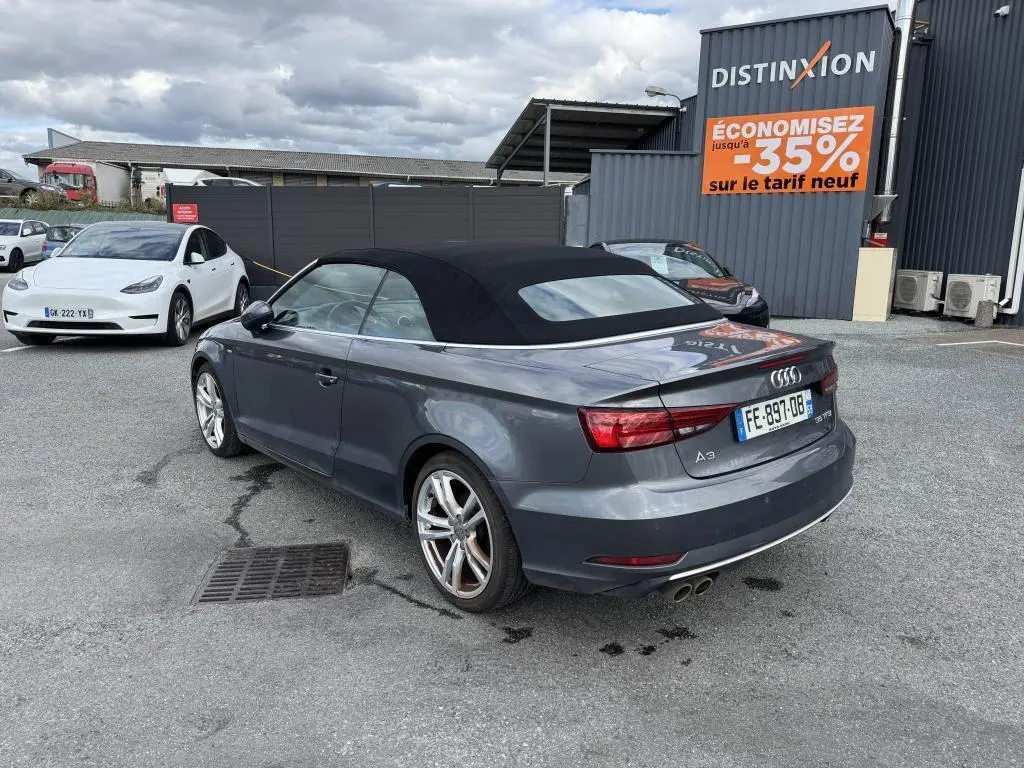 Audi A3 Cabriolet gris vue 3/4 arrière droit avec capote noire et jantes sport 5 branches.