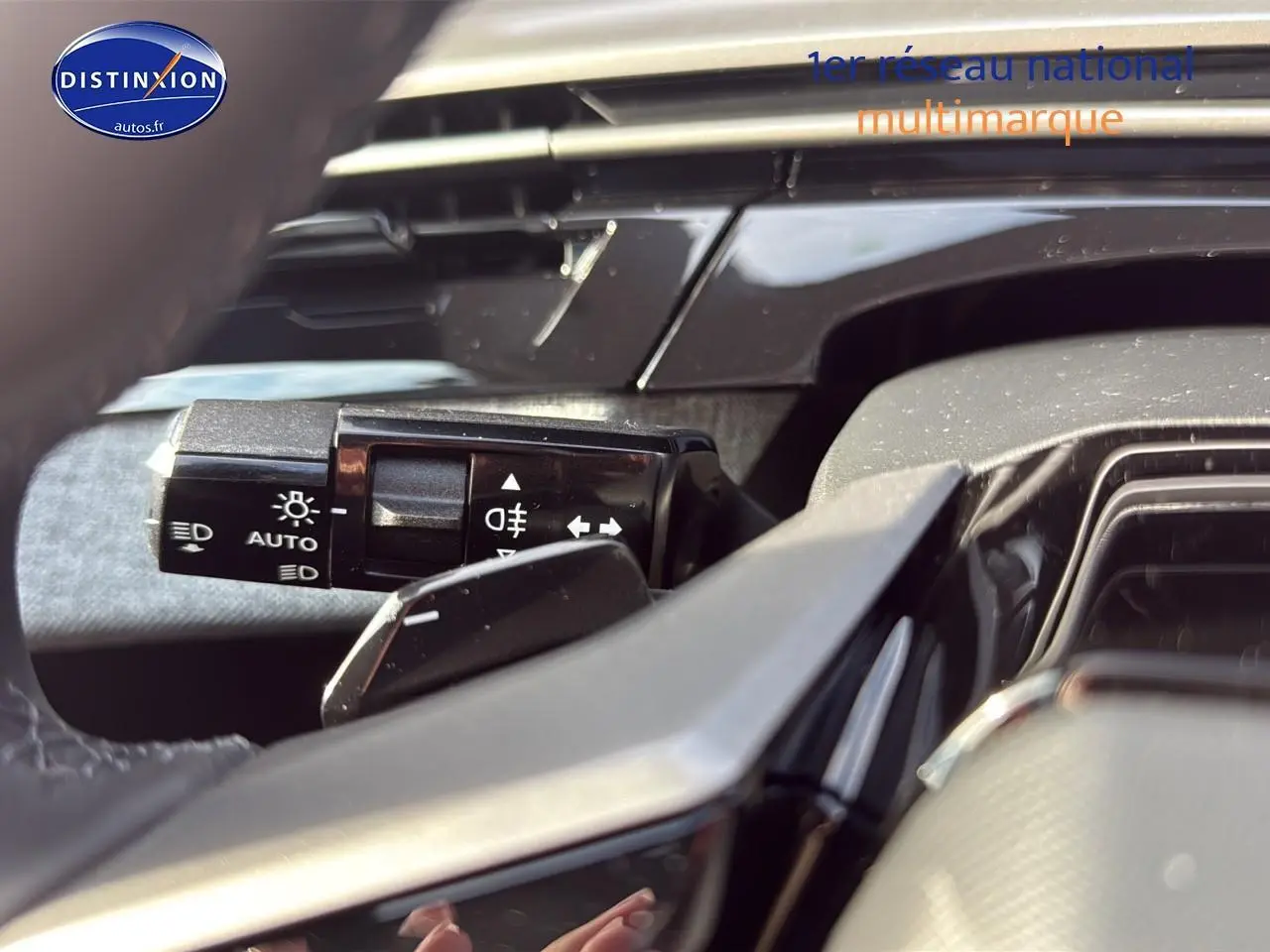 Gros plan sur la manette de commande des phares et clignotants dans l'habitacle du Peugeot 3008 gris titane.