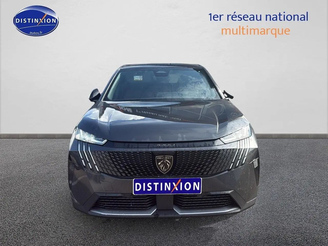 Vue frontale d'un Peugeot 3008 gris titane 2025 avec calandre noire et phares LED fins allumés.